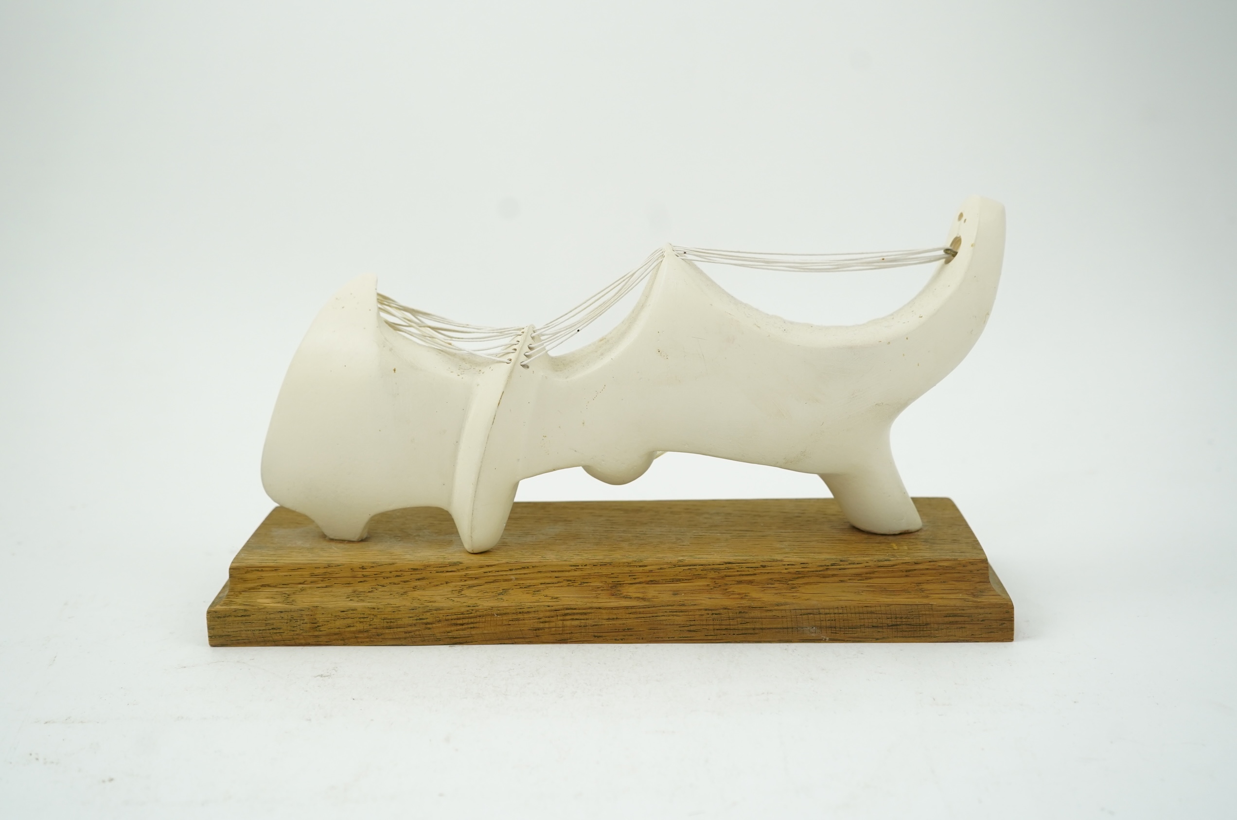 Follower of Henry Moore (1898-1986) A modernist stringed plaster sculpture raised on an oak rectangular plinth base, 25cm wide